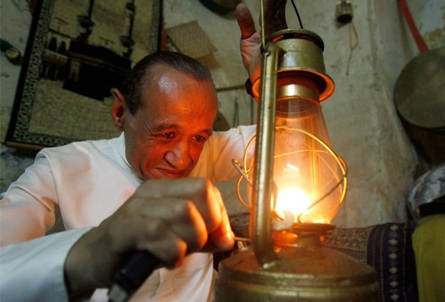 A Musaharati, dawn awakener, lights up a lantern before touring the streets with his drums to wake observant Muslims for their overnight 'sahur', last meal, before the day's fast in Sidon's Old City in south Lebanon just before dawn August 26, 2009.