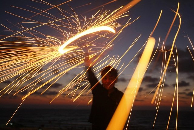 A Palestinian boy plays with a sparkler on the eve of the Muslim holy fasting month of Ramadan in Gaza City on August 21, 2009.