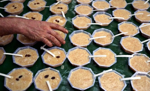 A Muslim man arranges bowls of a traditional dessert called kheer for sale outside a mosque before the evening prayers on the first day of the holy month of Ramadan, in Jammu, Jammu and Kashmir, Indian-administered Kashmir on August 23, 2009.