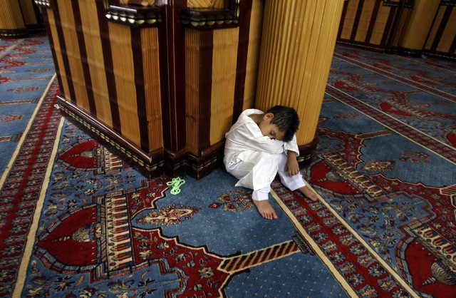 A Muslim boy takes a nap during evening prayers called "Tarawih" at Mosque of Gamal Abdel Nasser in Tripoli, Libya on August 22, 2009. The mosque was converted from the Catholic Cathedral of the Sacred Heart of Jesus after a 1969 coup by Libyan leader Muammar Gaddafi. 