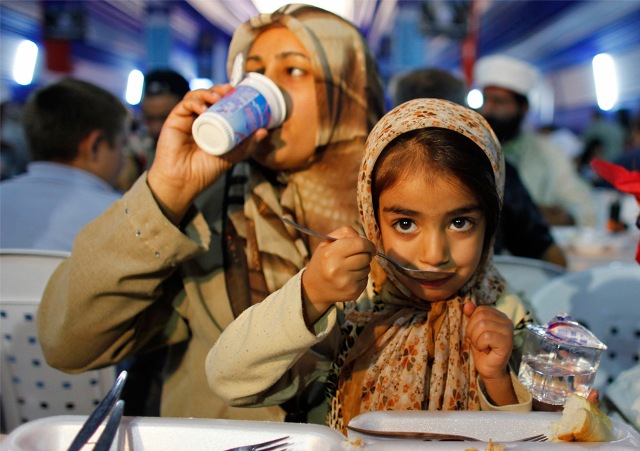 A Muslim family eats, breaking their fast in a giant tent on the first day of the holy month of Ramadan in Istanbul, Turkey on August 21, 2009.