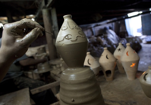 A Palestinian potter engraves the expression in Arabic "Ramadan Karim" as he puts the final touches to a clay lantern at his workshop in Gaza City on August 17, 2009, ahead of the start of the holy month of Ramadan.