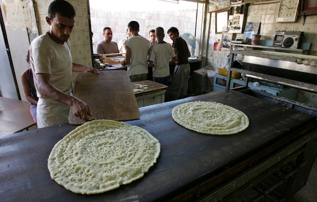 Jordanian workers make qatayef, a pancake-like shell filled with nuts or sweet cheese, fried in oil or baked, then dipped in sugary syrup in Amman, Jordan on Sunday August 23, 2009.